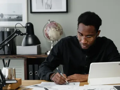 Man vult papieren in aan bureau