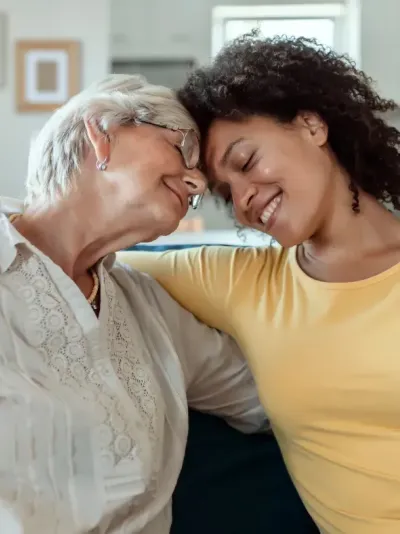 Deux femmes, l'une plus âgée, l'autre plus jeune, se prennent dans les bras.