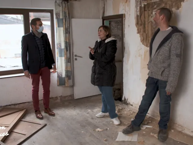 le notaire discute avec un couple dans leur maison en travaux