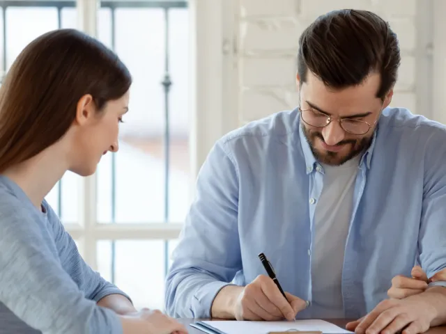 Un homme signe un acte d'achat chez son notaire.