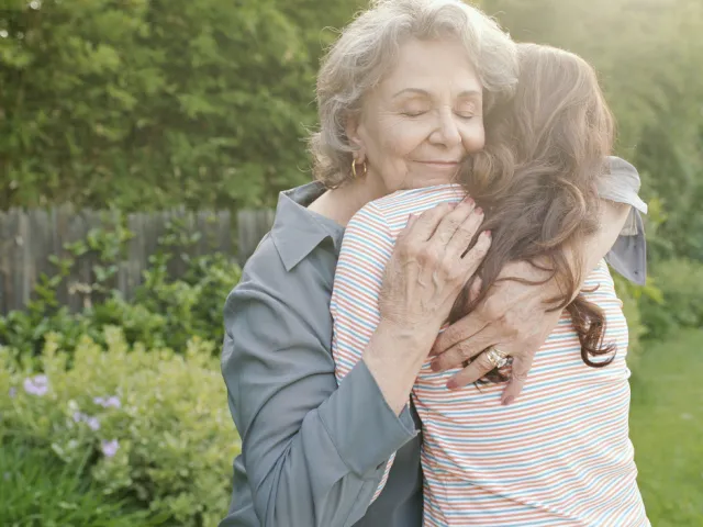 Une grand-mère fait un câlin à sa petite-fille.