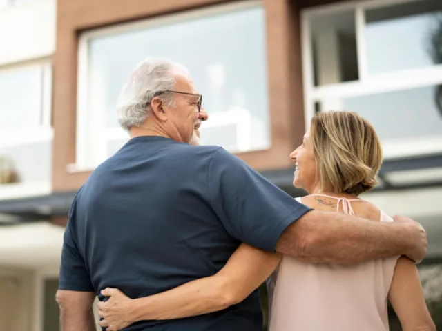 Un couple devant un immeuble d'appartements en France.