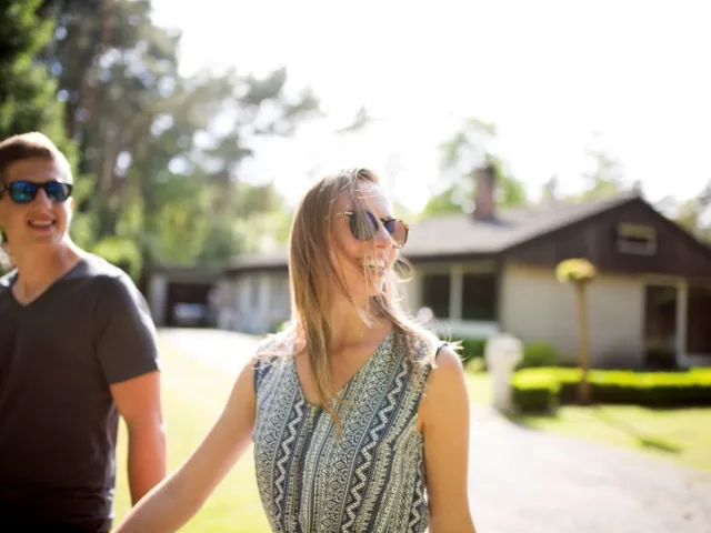 Un homme et une femme heureux dans le jardin de la maison dont ils sont nue-propriétaires.