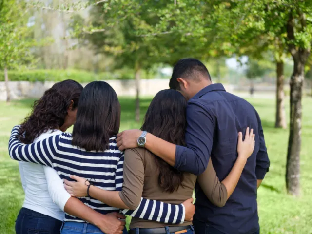 Une famille se prend dans les bras dans une période difficile.