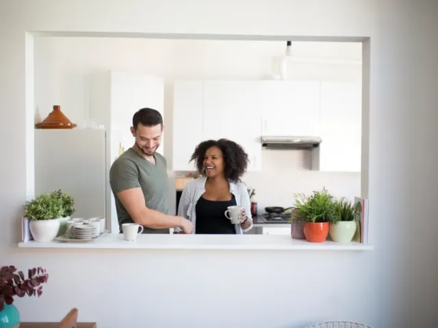 Un couple discute dans la cuisine de leur maison en France.