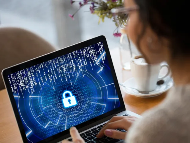 Une femme regarde son ordinateur et applique les conseils pour lutter contre la cybercriminalité.